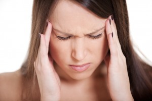 portrait of young woman with migraine against white background